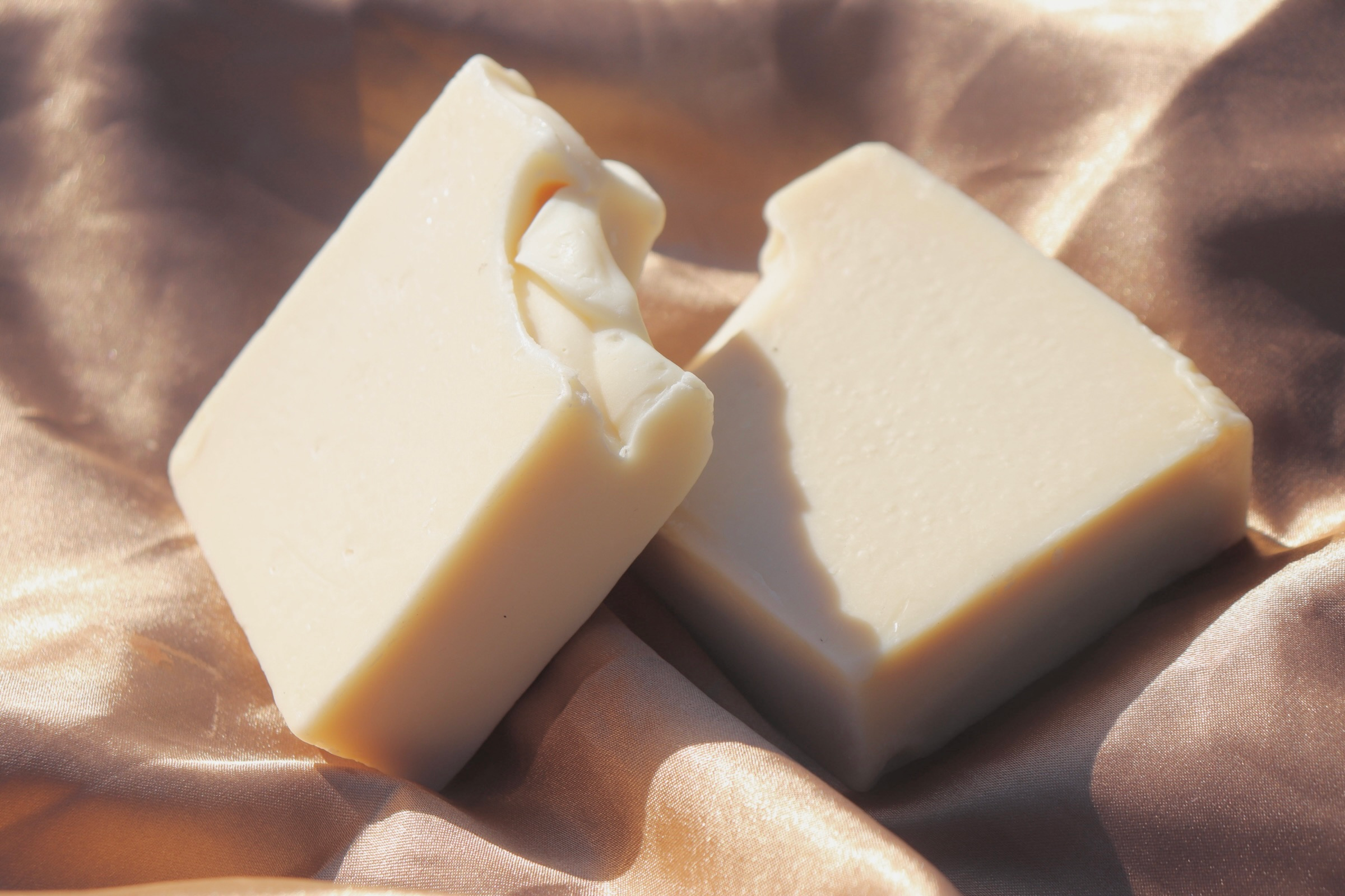 Tallow cleansing bar displayed on satin fabric