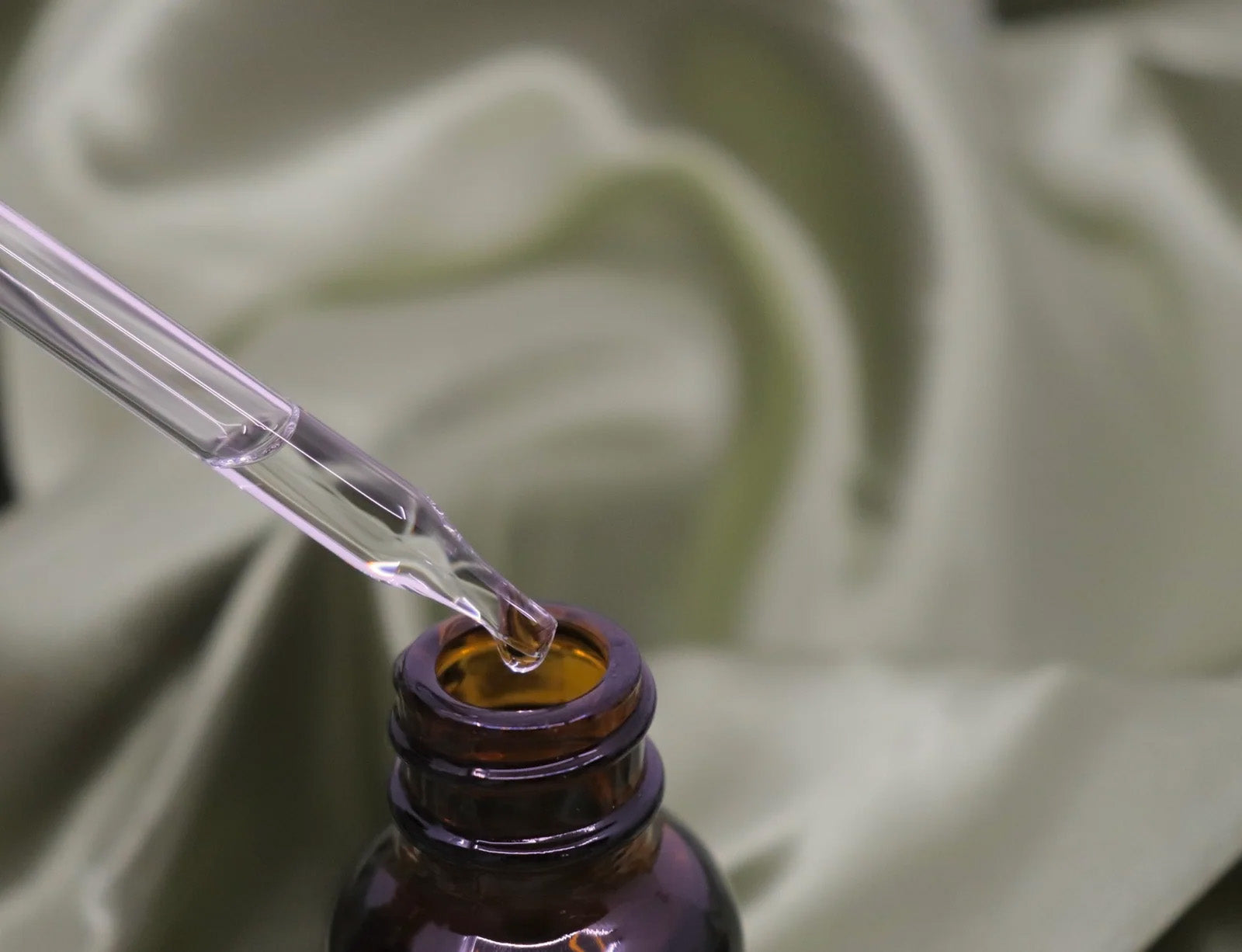 Organic Frankincense Essential Oil in a dropper bottle on silk fabric