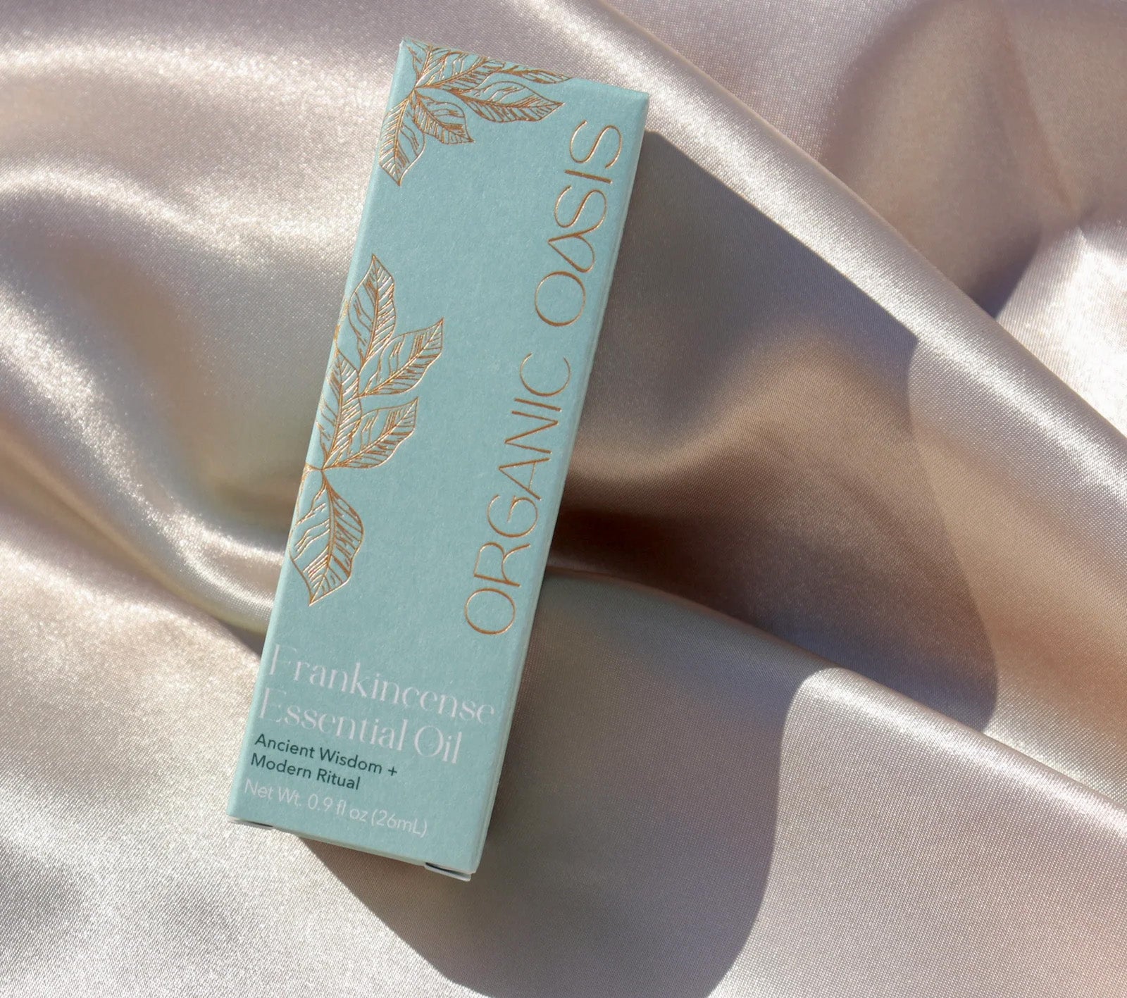 Organic Frankincense Essential Oil product packaging on silk fabric