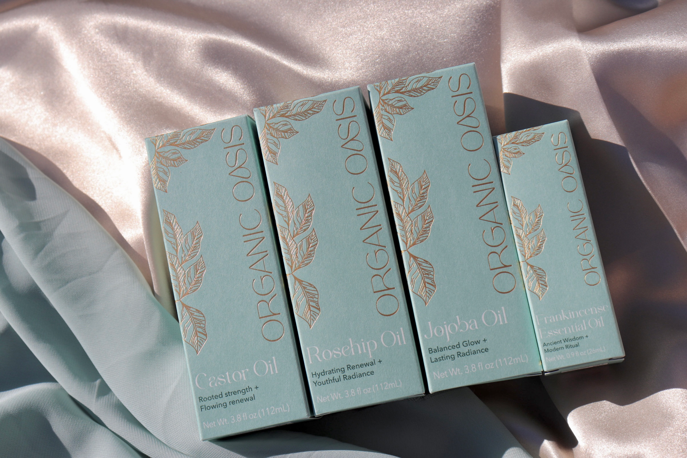 Organic Oasis Luminous Collection featuring botanical skincare oils in premium packaging.