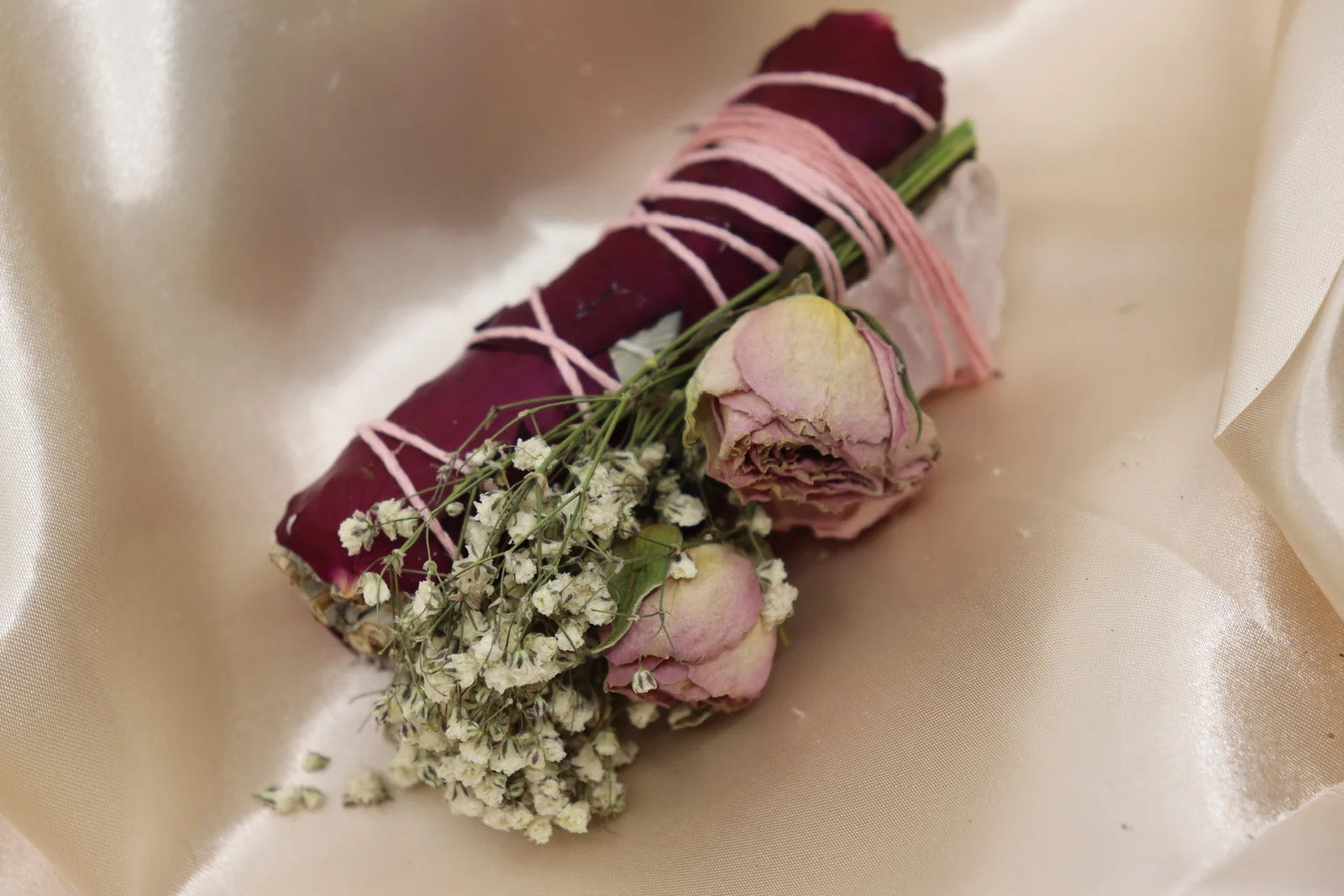 Close-up of sage bundle wrapped with dried flowers