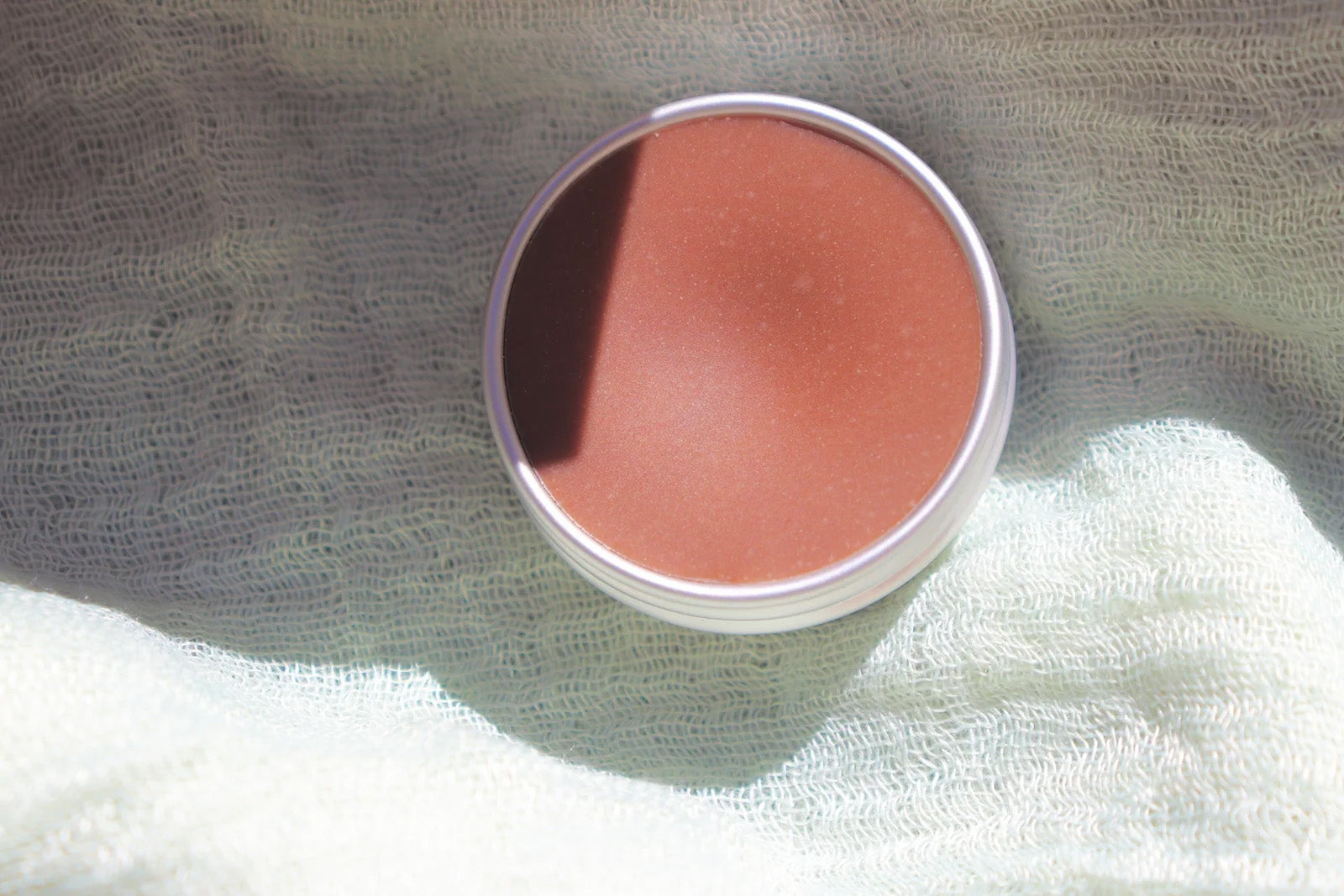Cacao lip butter in an open cosmetic tin
