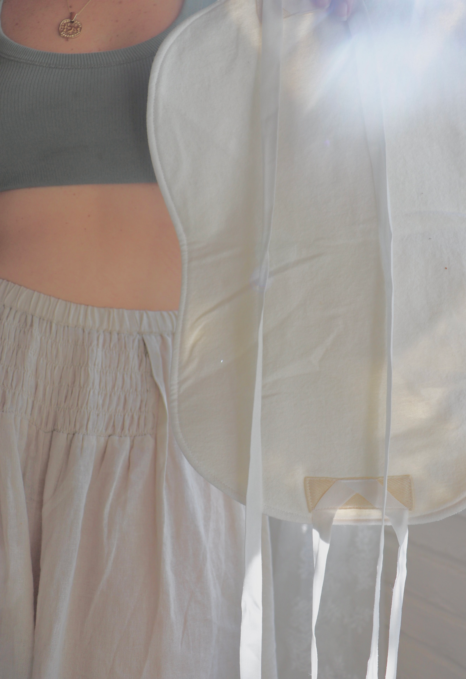 Woman wearing a reusable castor oil pack
