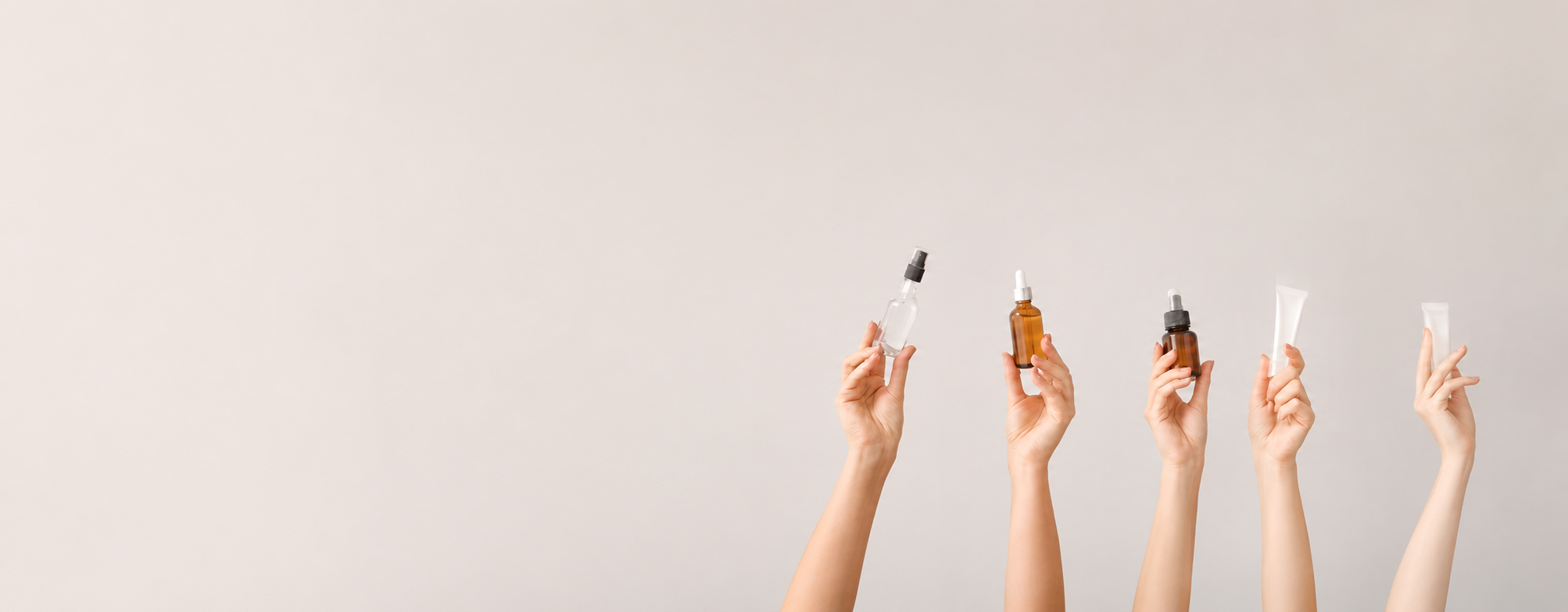 Five hands holding small organic oasis  bottles with droppers against a light gray background