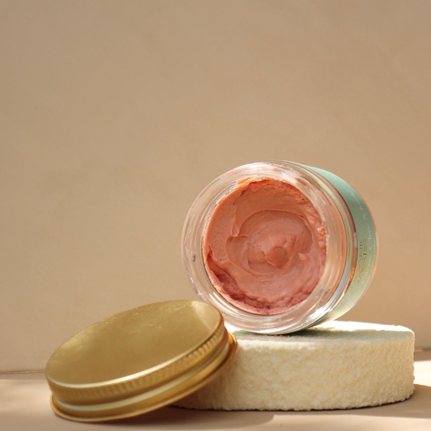 Rose Clay Face Mask with pink clay inside the jar
