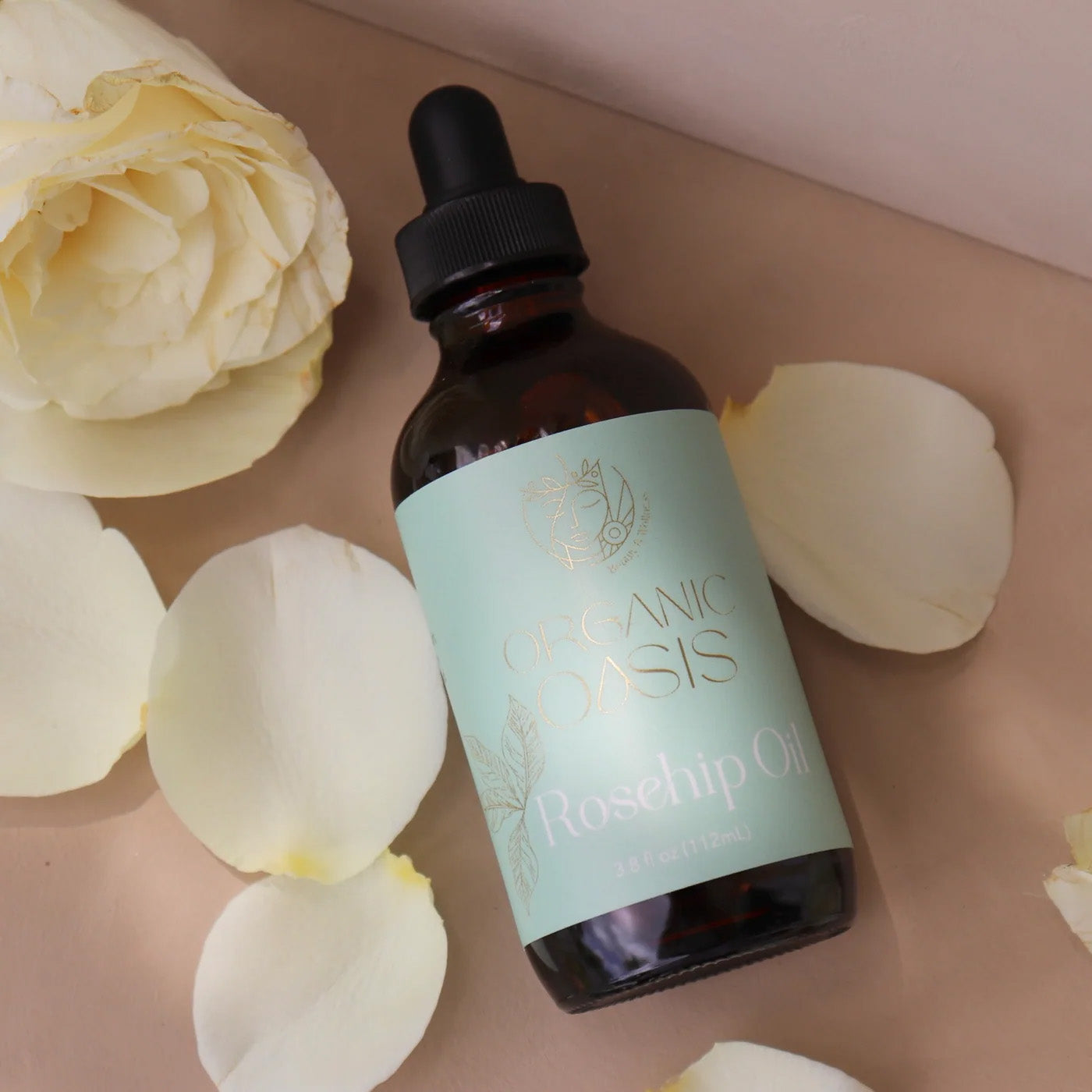 Organic Cold-Pressed Rosehip Oil bottle with rose petals by Organic Oasis