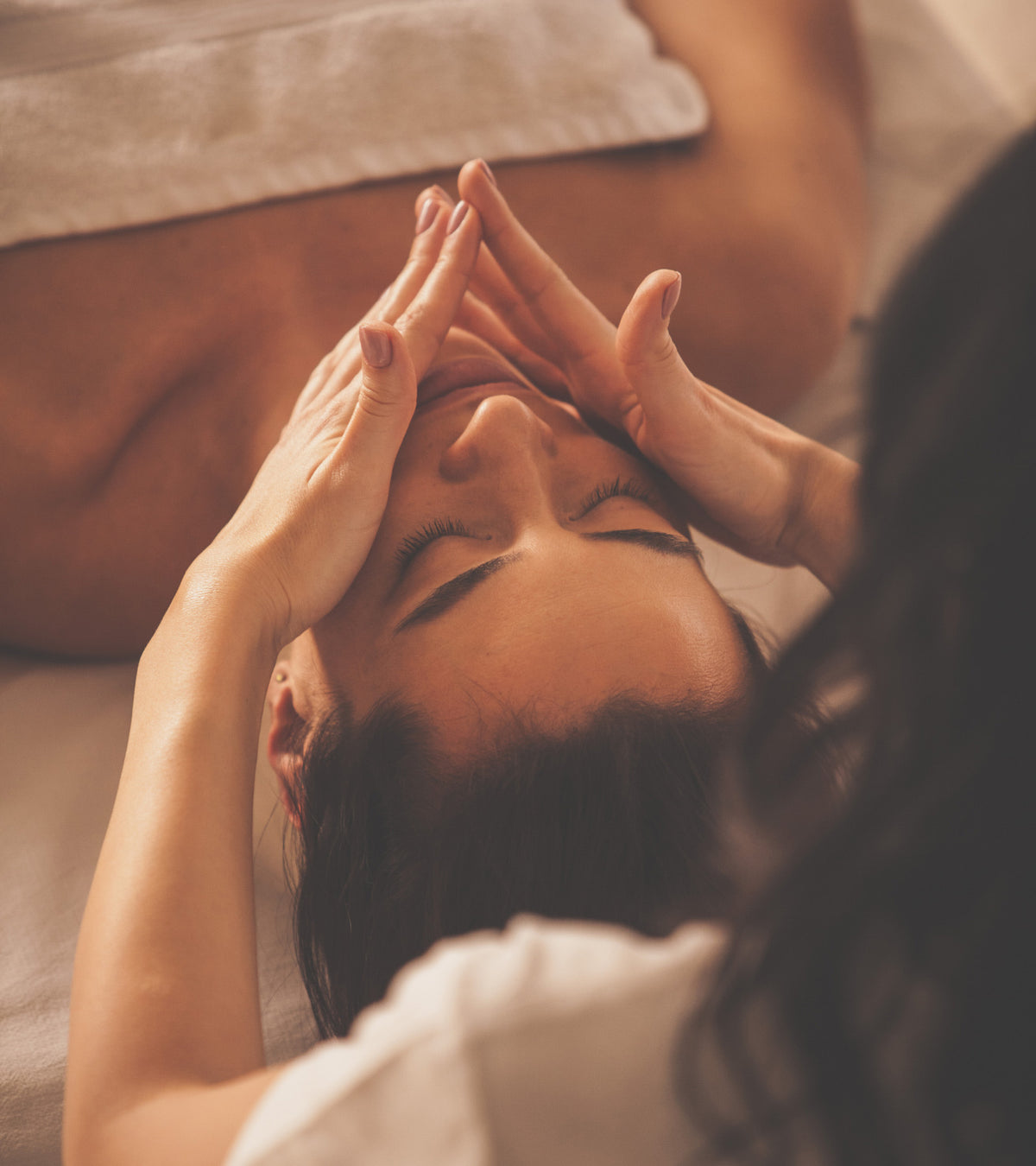 Person receiving a head massage in a spa setting ORGANIC OASIS 